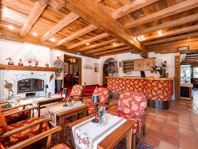 Gemütliche Hotel-Lobby mit Holzdecke, Kamin und gemütlichen Sitzgruppen in warmen Farben.