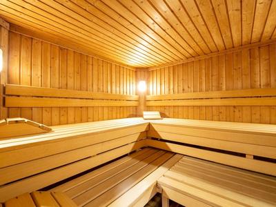 Innenraum einer traditionellen finnischen Sauna mit Holzverkleidung und Bänken.