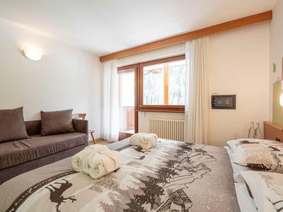 Gemütliches Hotelzimmer mit Doppelbett und Sofa, hell und einladend dekoriert.