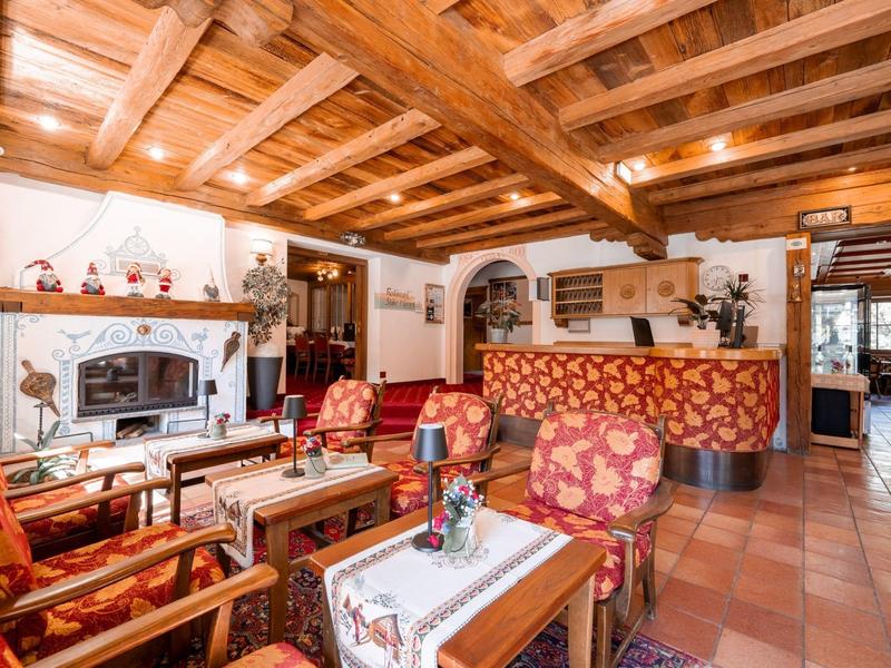 Gemütliche Hotel-Lobby mit Holzdecke, Kamin und gemütlichen Sitzgruppen in warmen Farben.