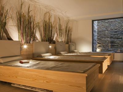 Nowoczesne, minimalistyczne pokoje hotelowe z drewnianymi łóżkami i dekoracyjnymi roślinami na ścianie.