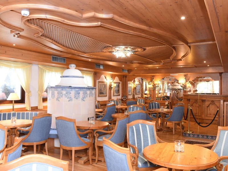 Przytulna restauracja hotelowa z drewnianym sufitem i niebieskimi krzesłami