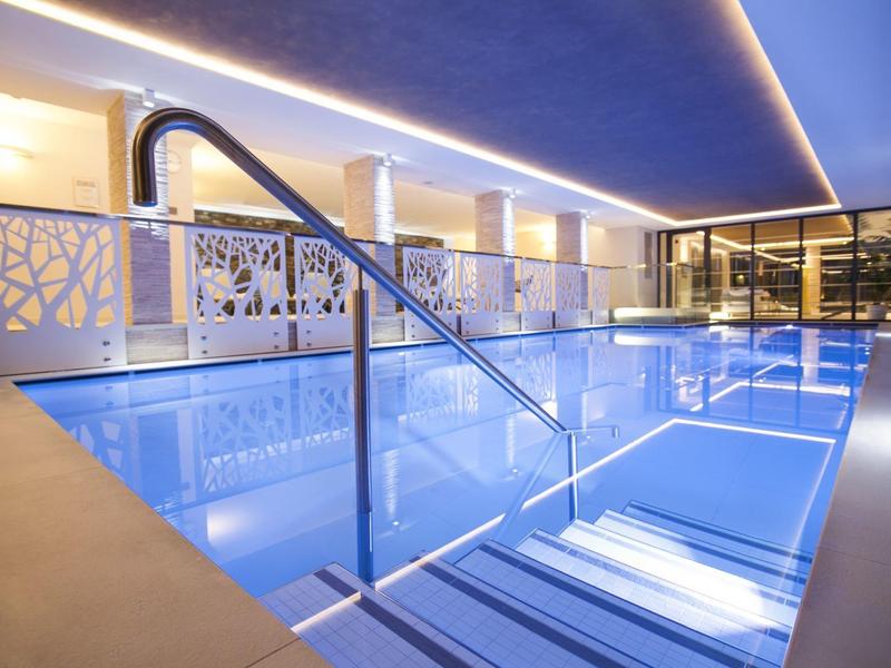 Basen wewnętrzny z nowoczesnym designem i oświetleniem w hotelu