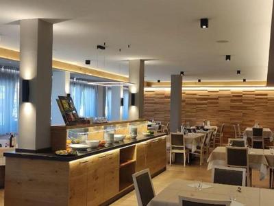 Modernes Hotelrestaurant mit Holzmöbeln und gemütlicher Beleuchtung.