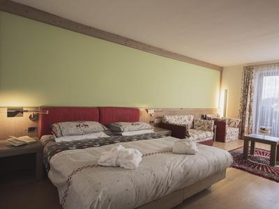 Modernes Hotelzimmer mit Doppelbett, Sitzbereich, großem Fenster und hellem Ambiente.