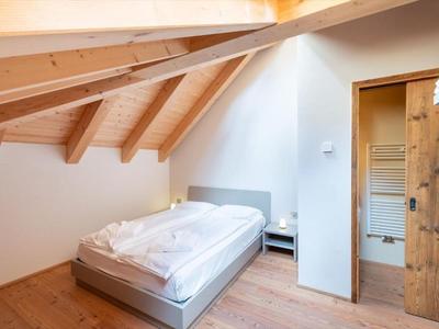 Gemütliches Schlafzimmer unter Dachschräge mit Doppelbett und Holzboden.
