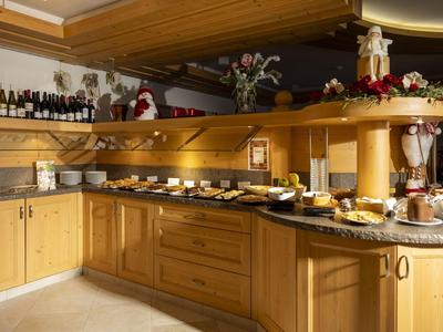 Buffetbereich mit Holztheke, verschiedenen Getränken und Frühstücksoptionen in einem Hotel.