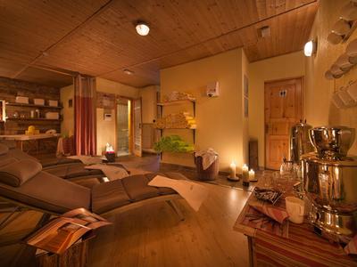Gemütlicher Wellnessraum mit Liegen, sanfter Beleuchtung und Holzvertäfelung.