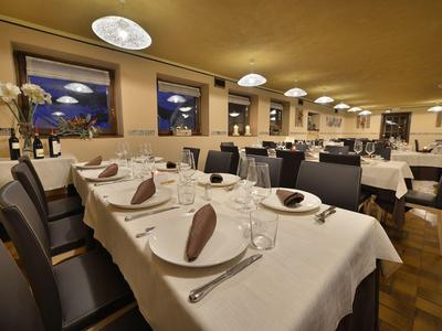 Elegantes Hotelrestaurant mit gedeckten Tischen und modernen Stühlen in warmem Licht.