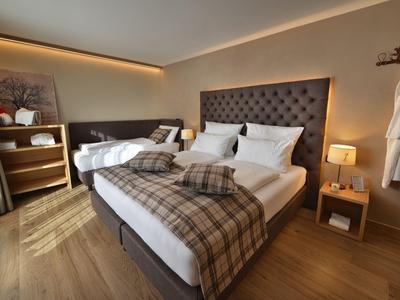 Modernes Hotelzimmer mit zwei Betten, Holzfußboden und gemütlicher Beleuchtung.