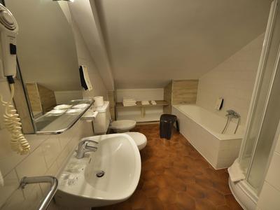 Helles Badezimmer mit Dusche, Badewanne und Waschbecken in einer Hotelunterkunft.