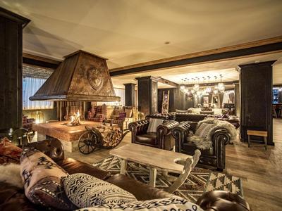 Warmer, gemütlicher Hotel-Lobby-Bereich mit Ledersofas und einem großen zentralen Kamin.