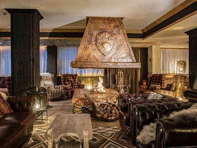 Gemütlicher Hotel-Lounge mit Ledersofas, Kamin und warmem Ambiente.