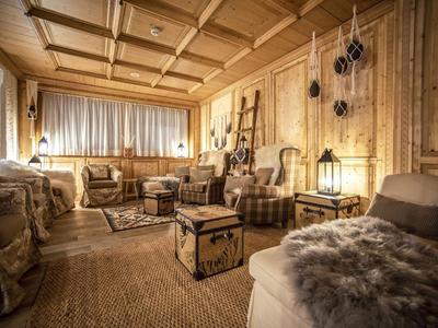 Gemütlicher, holzverkleideter Hotel-Loungebereich mit rustikalen Möbeln und warmem Licht.