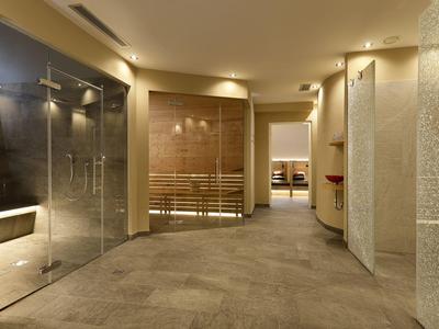 Moderner Wellnessbereich mit Sauna, Glasdusche und entspannter Beleuchtung.