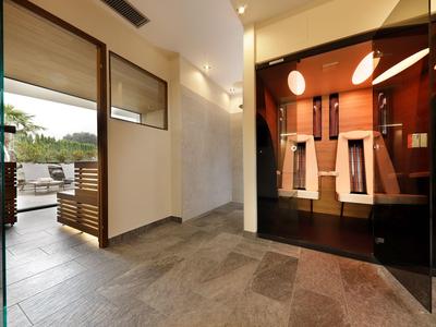 Moderner Wellnessbereich mit Sauna und Blick auf eine Terrasse mit Sitzgelegenheiten.