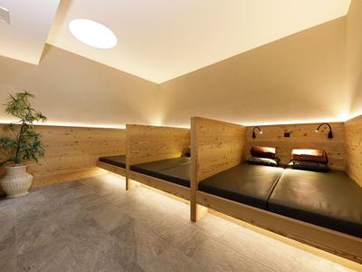 Moderner Ruheraum mit Holzmöbeln, Beleuchtungselementen und Pflanze im Hotel.