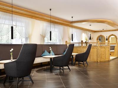 Modern eingerichteter Hotel-Loungebereich mit gemütlichen Sesseln und Holztresen.