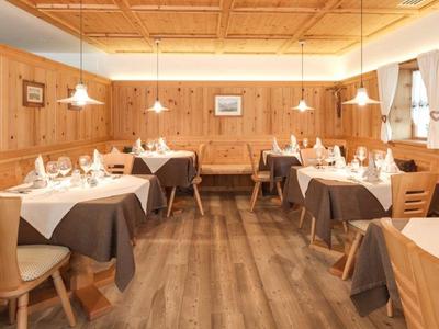 Ein gemütliches Restaurant mit Holzwänden und gedeckten Tischen in einem Hotel.
