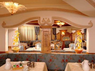 Restaurante elegante de hotel con luz cálida, espejos decorativos y mesas preparadas.