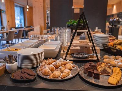 Buffet mit Gebäck, Kuchen und Keksen in einem hellen Hotelrestaurant.