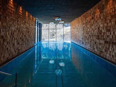 Innenpool mit Holzvertäfelung und großem Fenster für Tageslicht im Hotel.