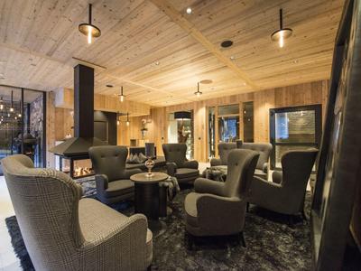 Moderner Hotel-Loungebereich mit gemütlichen Sesseln und Holzdecke.