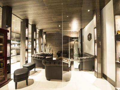 Eleganter Hotel-Loungebereich mit dunklen Möbeln, Holzdecken und warmem Licht.