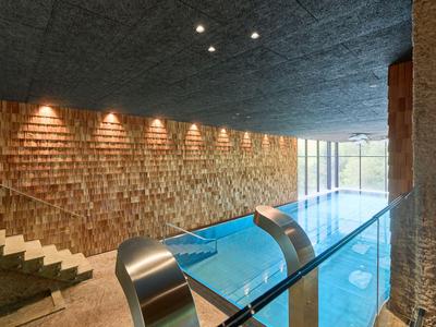 Moderner Innenpool mit Holzvertäfelung und großen Fenstern in einem Hotel.
