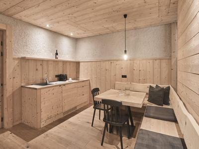 Gemütliche Eckbank und Holzmöbel in einem hellen, modernen Hotelzimmer mit Holzvertäfelung.