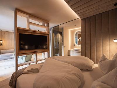 Camera d'hotel moderna con dettagli in legno e un letto matrimoniale accogliente.
