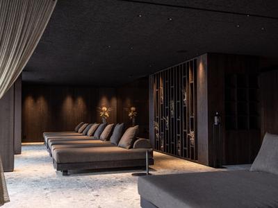Area spa scura dell'hotel con comodi lettini e illuminazione soffusa.