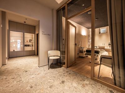 Ingresso moderno dell'hotel con vista su una sala riunioni e illuminazione luminosa.
