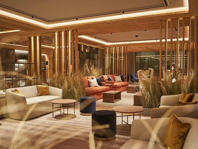 Moderně zařízená hotelová hala s pohovkami, křesly a teplým osvětlením.