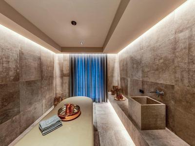 Moderní spa místnost s lehátkem, ručníky a jemným osvětlením.