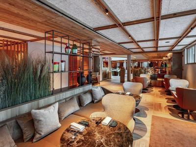 Pohodlná hotelová lounge s moderním sezením, dřevěnými prvky a přírodní výzdobou.