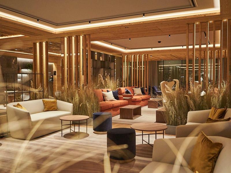 Moderní hotelová lounge s pohodlnými křesly a teplým osvětlením.
