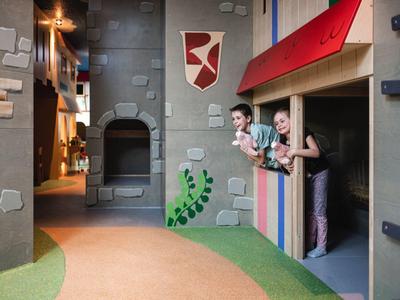 Children's play area with castle wall for climbing and colorful, themed interior.