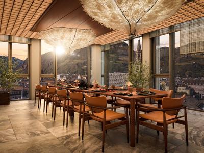 Elegantes Speisezimmer mit Holzmöbeln, großen Fenstern und dekorativem Baum in modernem Design.