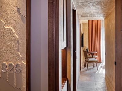 Pasillo con puertas de madera y silla, número de habitación 329 en una sección de pared texturizada.