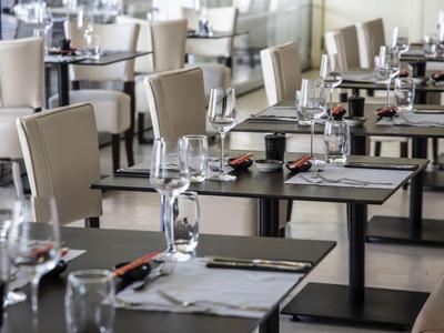 Moderní jídelna s pohodlnými židlemi a prostřenými stoly v hotelové restauraci.