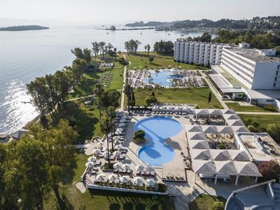 Grande hotel con piscina e giardino vicino al mare in una posizione soleggiata.
