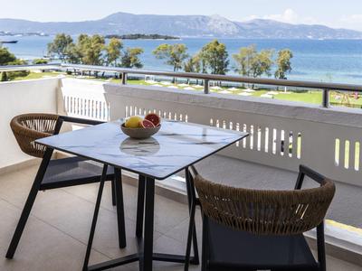 Balcone con tavolo e due sedie con vista sul mare e sulle montagne in una giornata limpida.