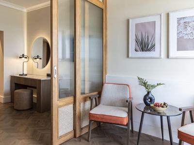 Lounge d'hotel moderna con poltrone, tavolo e quadri decorativi alla parete