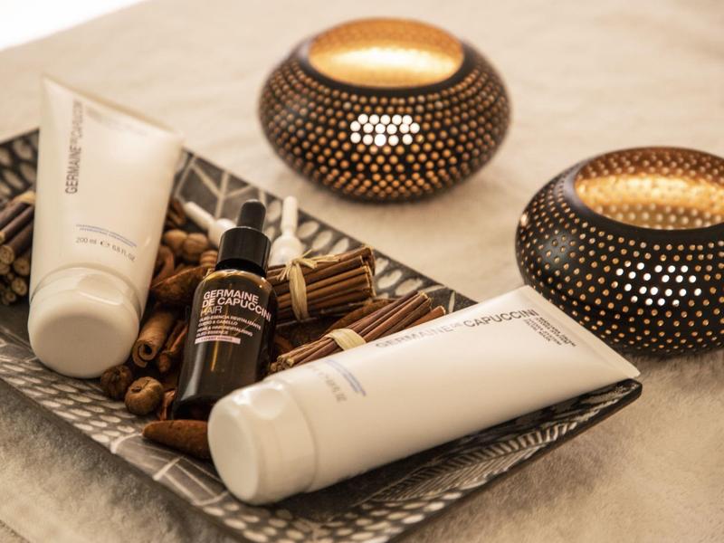 Set benessere con creme e candele profumate in un cestino su un tavolo