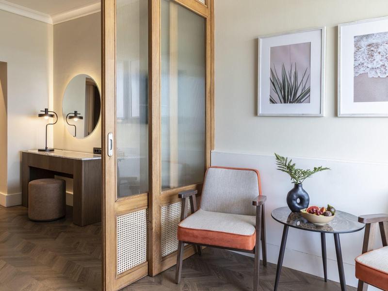 Lounge d'hotel moderna con poltrone, tavolo e quadri decorativi alla parete