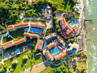 Vista aerea di un complesso alberghiero con piscine vicino alla spiaggia.