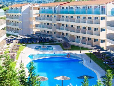 Hotel moderno con piscina a forma libera e lettini intorno.