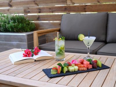 Rinfreschi estivi con frutta fresca e cocktail su un tavolo di legno all'aperto.