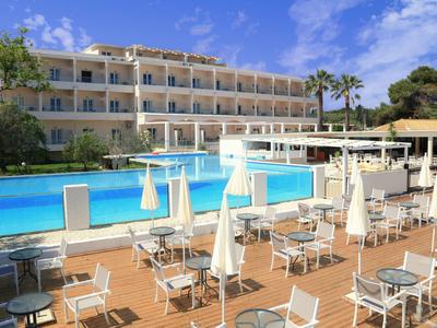Hotel con grande piscina, terrazza con tavoli e ombrelloni sotto il cielo sereno